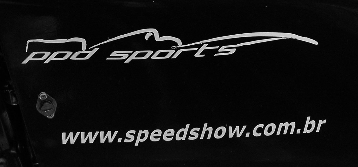 Close-up of the dark engine cover of a racing car: a script logo reading ppd sports under a line drawing of a single-seater, and the web address www.speedshow.com.br below it.
